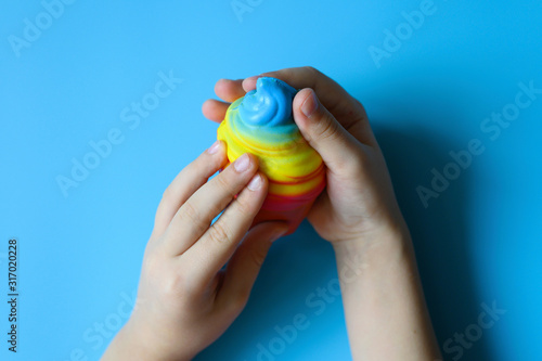 anti stress squishy toy in the form of multicolored ice cream in children's hands on blue background photo