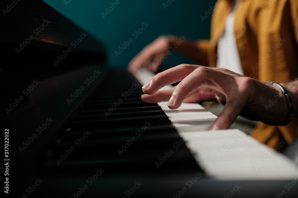 Fototapeta premium Male hands playing keyboard at the studio