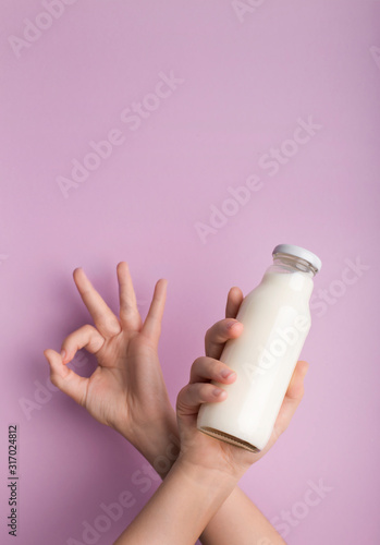 Glass bottle with coconut detox drink in woman hand