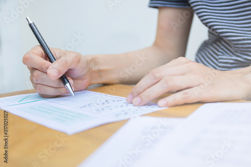 high school,university student study.hands holding pencil writing paper answer sheet.sitting lecture chair taking final exam attending in examination classroom.concept scholarship for education abroad © panitan