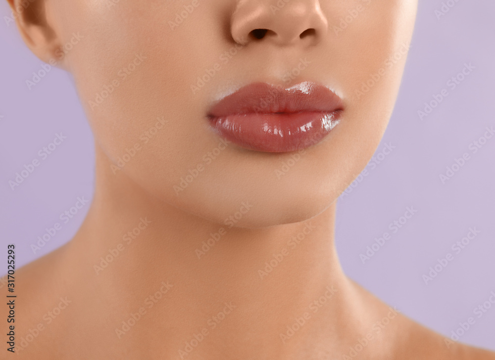 Young woman with beautiful full lips on lilac background, closeup Young woman with beautiful full lips on lilac background, closeup