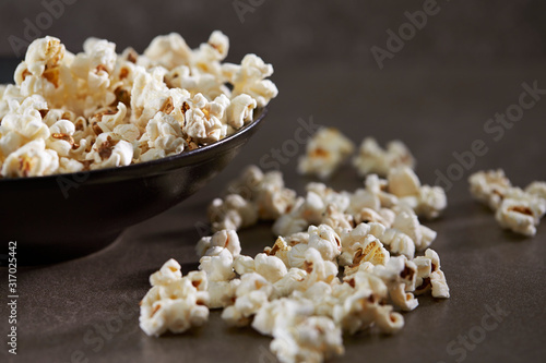 Popcorn in black bowl on black background 