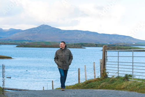 smiling man in glasses walking on road