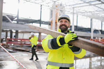 Men workers walking outdoors on construction site, working.