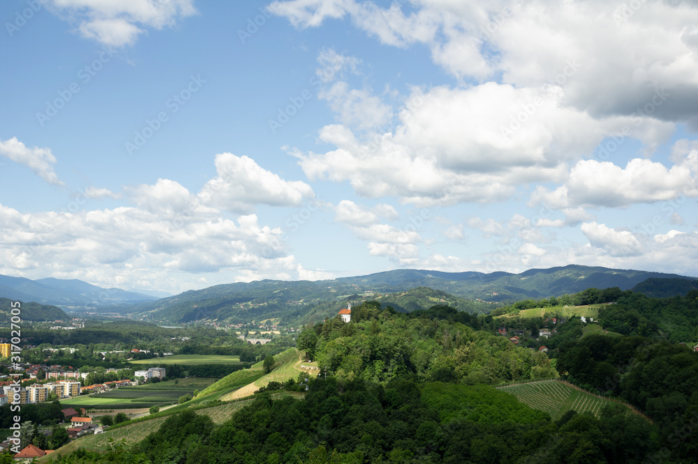 City of Maribor in Slovenia is surrounded by Kalvarija hill and nature. Blue sky with cloud as large copy space