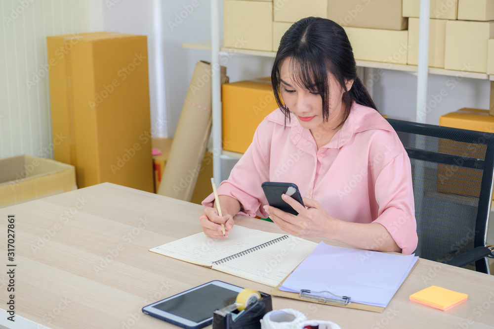 Asian charming beautiful girl entrepreneur look to outside about project plan and her store in modern working room. Asian charming beautiful girl entrepreneur look to outside about project plan and her store in modern working room.