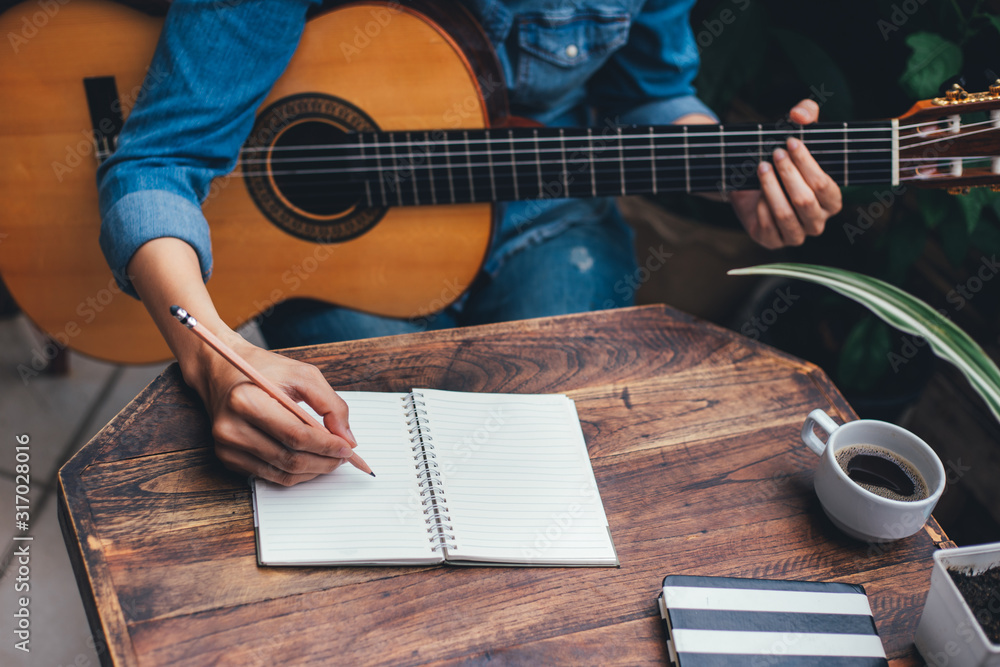 Fototapeta premium artist songwriter thinking writing notes,lyrics in book at studio.man playing live acoustic guitar relax chill.concept for musician creative.composer work process.people relaxing time with instrument