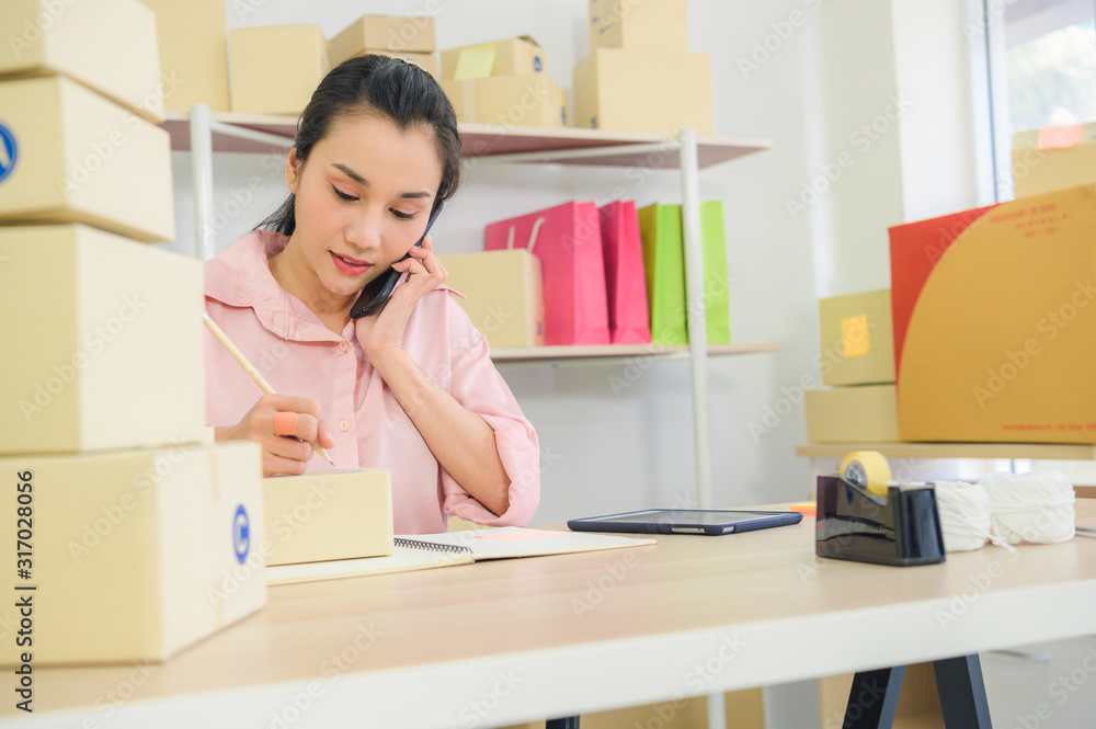 Asian woman enjoy herself while using internet on laptop and phone in office. Business and marketing and part time concept. Online shopping and business success theme. Asian woman enjoy herself while using internet on laptop and phone in office. Business and marketing and part time concept. Online shopping and business success theme.