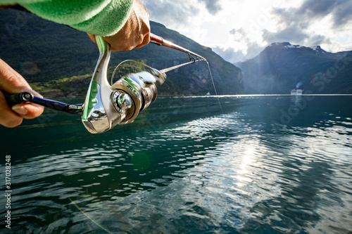 Foto Woman fishing on Fishing rod spinning in Norway.