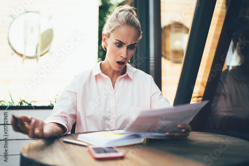 Woman surprised with information in paper document