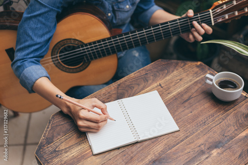 Fotografi artist songwriter thinking writing notes,lyrics in book at studio