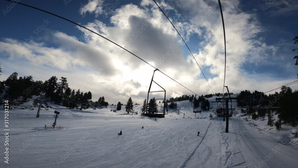 POV Riding on Ski Lift in Snowy Terrain and Cloudy Blue Sky, SLOW MOTION POV Riding on Ski Lift in Snowy Terrain and Cloudy Blue Sky, SLOW MOTION