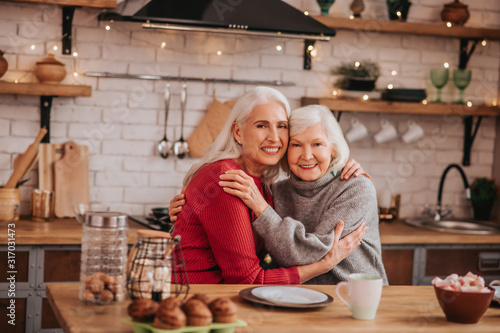 Two mature grey-haired positive ladies feeling great together