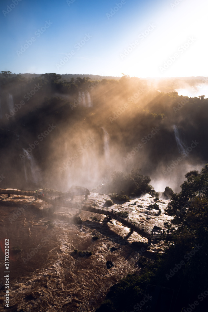 rayo de sol en pasarela de rio caudaloso en cataratas de Iguazu