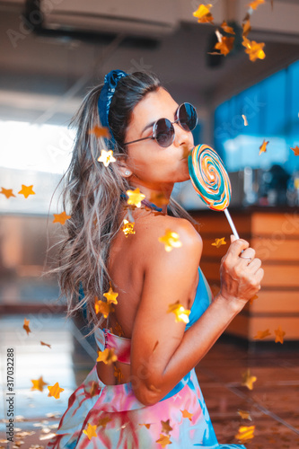 joven mujer posando con golosina dulce azucarado infantil y colorido © Marcos