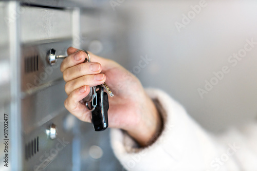 Close up of a woman unlocking apartment mailbox