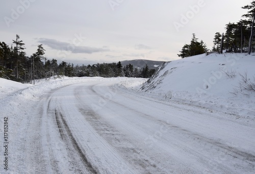 snow covered road after snow plow has passed in an rural area
