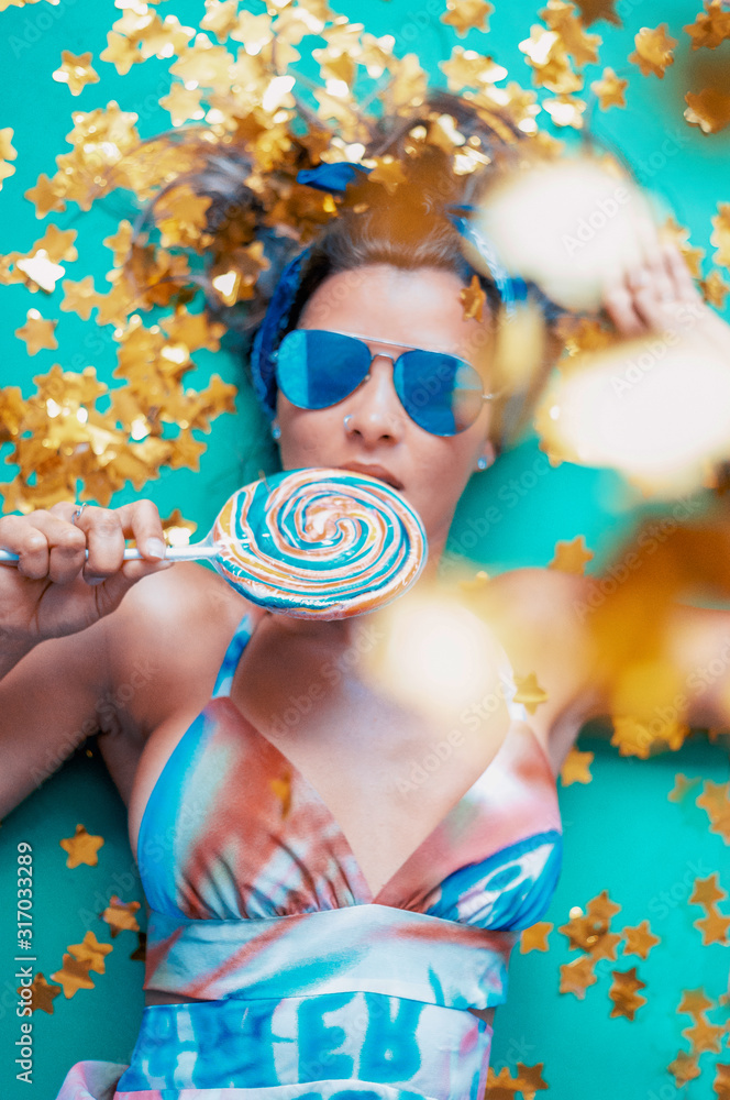 joven mujer posando con golosina dulce azucarado infantil y colorido