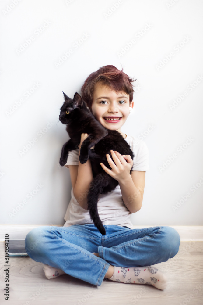 Vertical full length portrait little short haired schoolgirl with pink hair listening music on mobile phone with white wireless headphones and holding black cat in hands. Gadget addicted childhood Vertical full length portrait little short haired schoolgirl with pink hair listening music on mobile phone with white wireless headphones and holding black cat in hands. Gadget addicted childhood