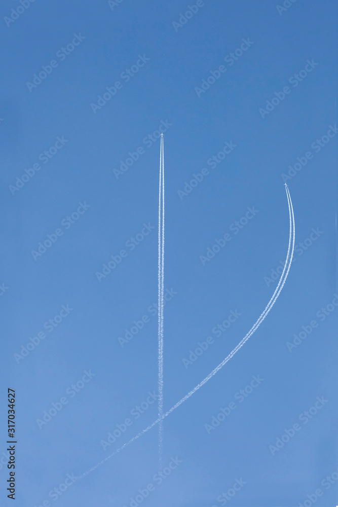Φωτογραφία two aircrafts in the ski make a graphic sign with condensation trails with copy