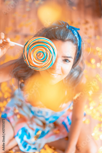 joven mujer posando con golosina dulce azucarado infantil y colorido