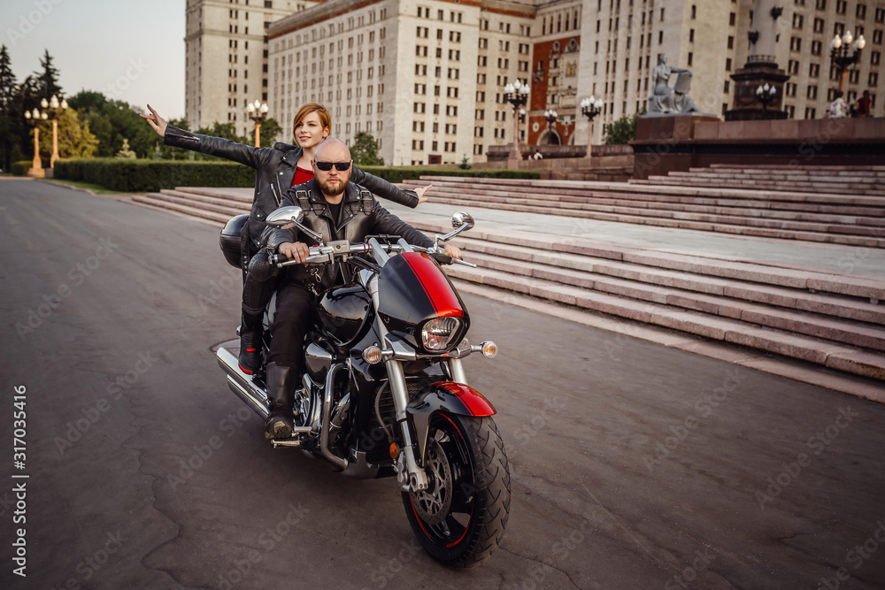 Beautiful couple on a cool motorcycle against Moscow