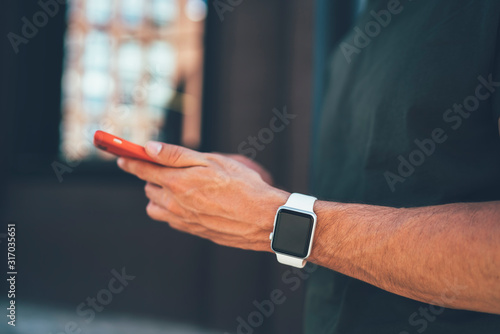 Concept of contemporary and advanced technology for human using, cropped image of male hands with electronic wristwatch searching useful information about mobile application connected to 4g