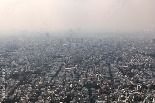 Dense air pollution and smog over Saigon, Vietnam (Ho chi Minh City). Overpopulated city, urban sprawl. Aerial view