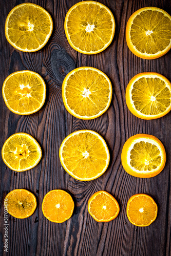 Cut orange fruits on wooden background top view mock up