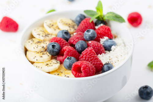 Healthy breakfast with granola, yogurt, berries and bananas. Tasty summer breakfast. 