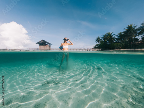 Caucasian traveller in snorkel mask feeling happiness and freedom during tropical vacations on Indonesian island with palm trees and crystal water for exploring ocean shallow, holidays on Raja Ampat