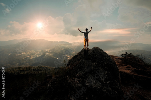 the man is standing on top of the mountain and enjoying the beautiful view. freedom financial.