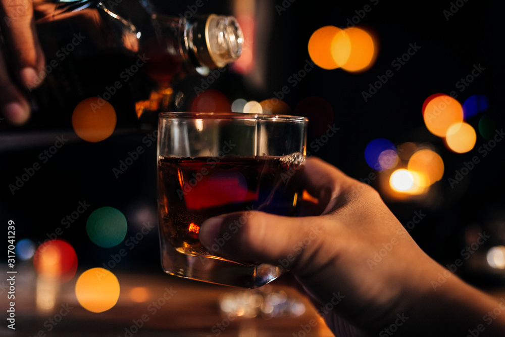 a glass of whiskey on wood bar, soft focus.