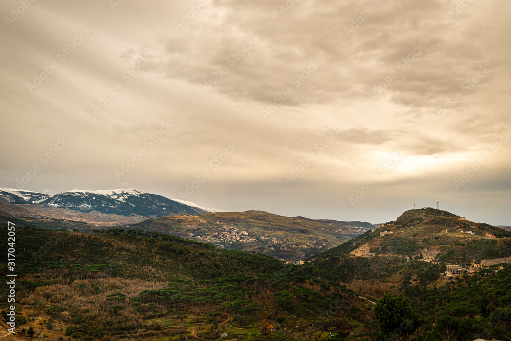 Naklejka premium The mountains of Lebanon were once shaded by thick cedar forests and tree is the symbol of country. Beautiful landscape of mountainous town in winter, Eco tourism, Chouf district with large vistas