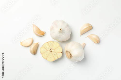 Fresh garlic bulbs, slices on white background, top view. Space for text photo