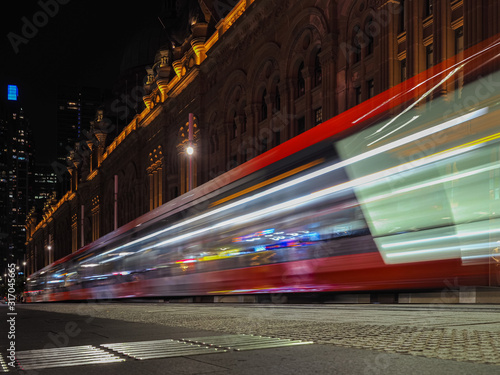 Sticker Motion blurred of Sydney tram public transport inside city center at night time