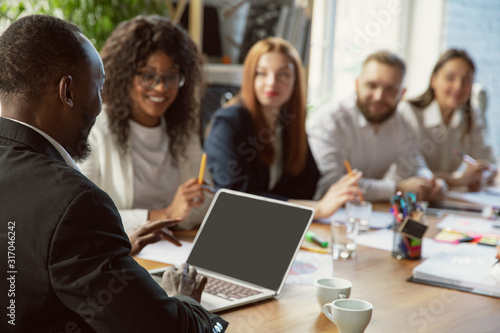 Happy emotions. Group of young business professionals having a meeting. Diverse group of coworkers discuss new decisions, plans, results, strategy. Creativity, workplace, business, finance, teamwork.