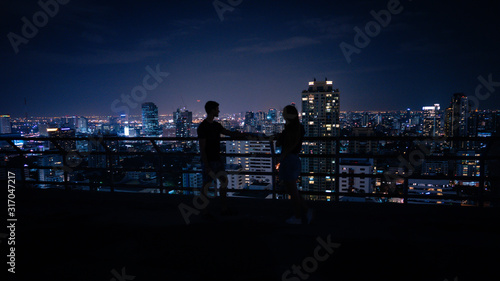 Photography Black silhouette of couple lover together on roof top of building for seeing do