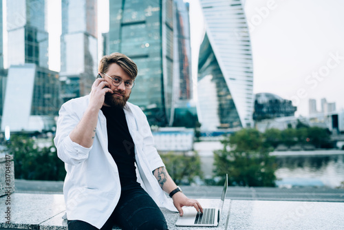 Serious remote worker calling colleague in business district