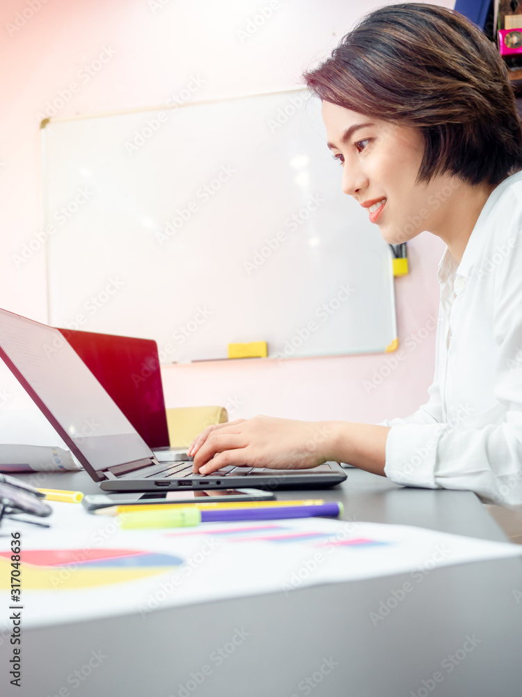 Beautiful happy Asian woman working with laptop computer on table in meeting room. Beautiful happy Asian woman working with laptop computer on table in meeting room.