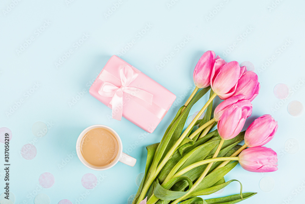 View from above tulips and gift box on blue. Background for womens day, 8 March Valentine's day, 14 february. Flat lay style, top view, mockup, template, overhead. Greeting card View from above tulips and gift box on blue. Background for womens day, 8 March Valentine's day, 14 february. Flat lay style, top view, mockup, template, overhead. Greeting card