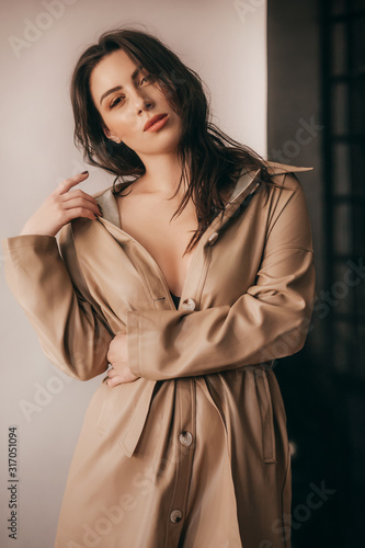 Portrait of beautiful young brunette girl with makeup in brown fashion clothes 
