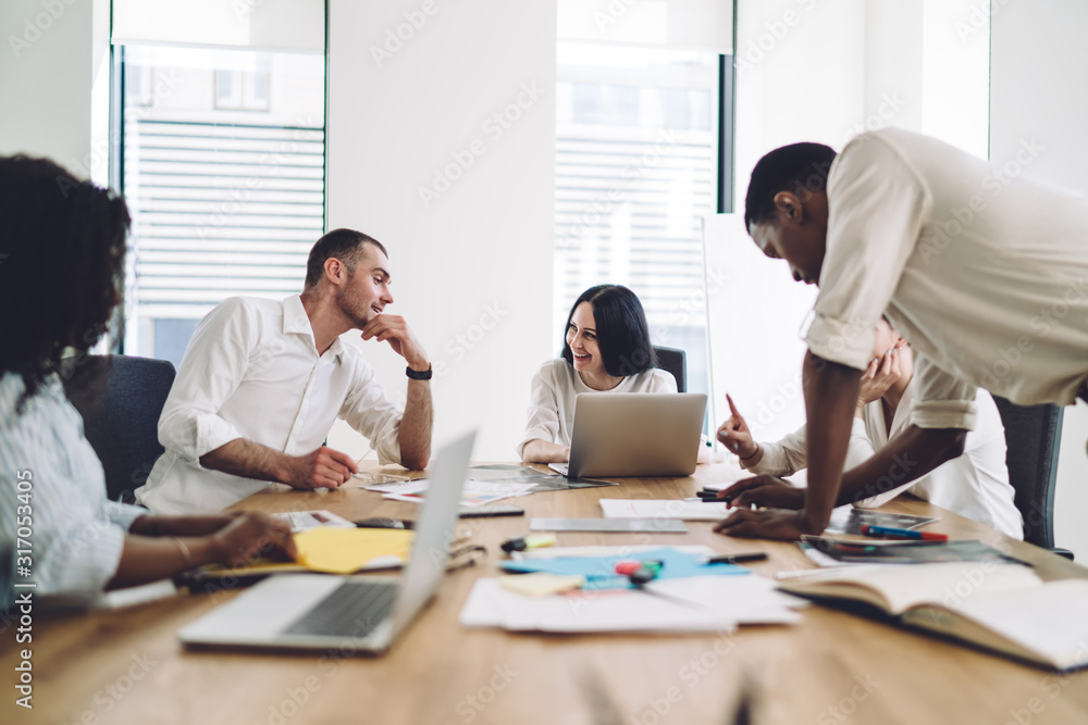 Coworkers smiling and talking during business meeting Coworkers smiling and talking during business meeting