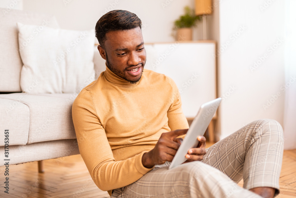 Relaxed Guy Using Digital Tablet Sitting On Floor At Home
