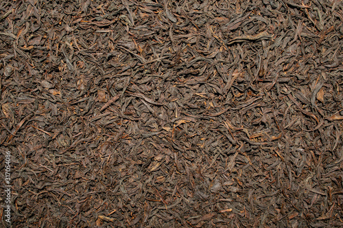 Background made of dried tea leaves. Black tea leaves backdrop.