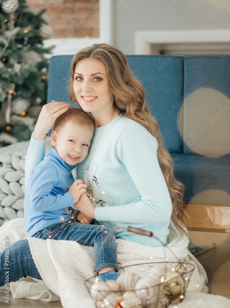 Happy boy with mather near Christmas tree Happy boy with mather near Christmas tree