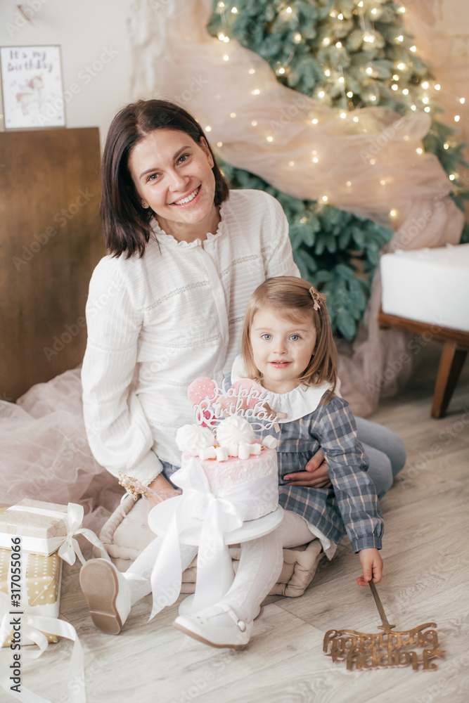 Happy girl with mother near Christmas tree Happy girl with mother near Christmas tree