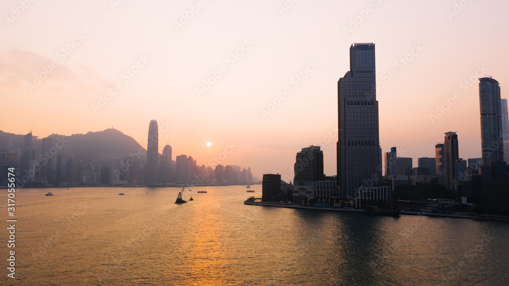 Aerial scenery panoramic view of Hong Kong Evening with metropolitan bay Victoria Harbor at sunset. Lighted Modern cityscape, urban skyline buildings. Energy power infrastructure. Popular Asian city