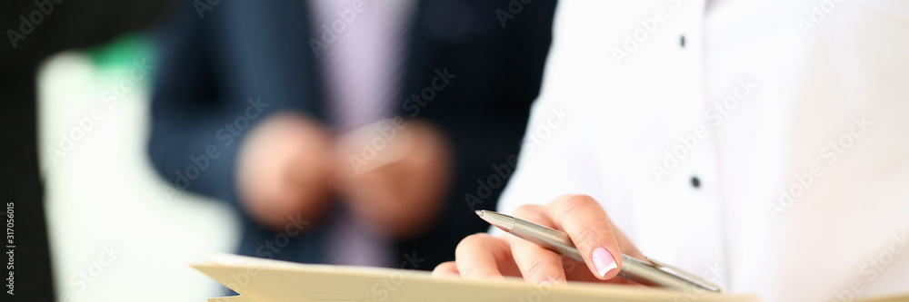 Female arm in shirt hold silver pen and pad making note in office closeup. Deal consult delivery signature financial inspector job fill survey form discuss strategy project negotiation concept