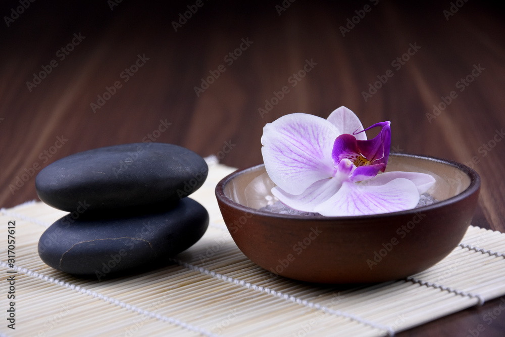 Massage stones with orchid stock images. Spa and wellness setting stock images. Pile of black stones. Black stones on a nature background. Spa-concept with zen stones and orchid flower stock images Massage stones with orchid stock images. Spa and wellness setting stock images. Pile of black stones. Black stones on a nature background. Spa-concept with zen stones and orchid flower stock images